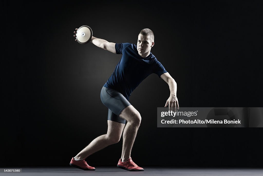 Male athlete throwing discus