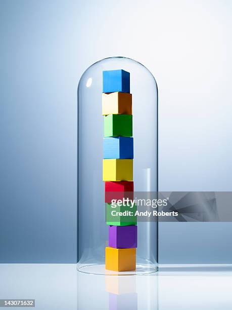 stack of colorful cubes under glass jar - guarding stock-fotos und bilder