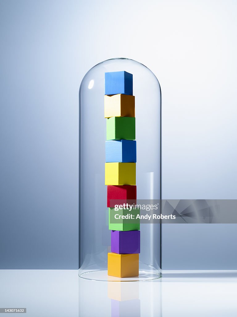 Stack of colorful cubes under glass jar