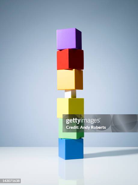 tiny block in stack of colorful cubes - stacking tables stock pictures, royalty-free photos & images