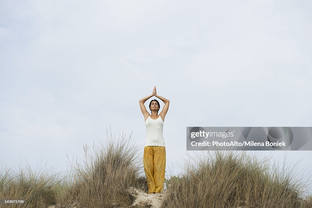 Mature woman doing sun salutation yoga pose