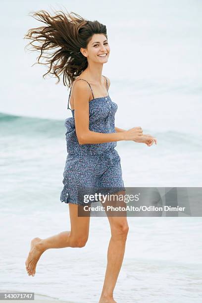 young woman running at the beach - tossing hair facing camera woman outdoors stock pictures, royalty-free photos & images