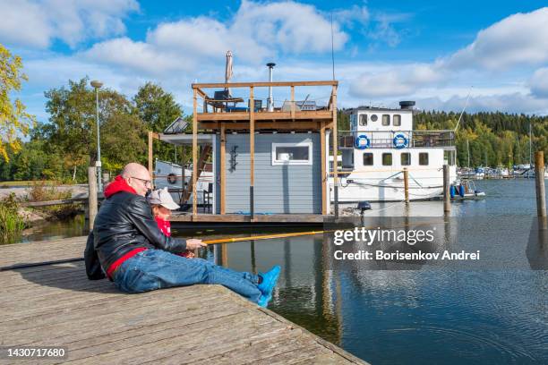 caucasian family fishing on the lake. a man and a girl, a child of 7 years old, are fishing with a line. - fisherman 50 years old stockfoto's en -beelden