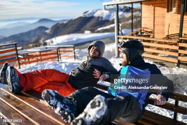 relaxed males having chat while sitting on benches after skiing on mountain - netherlands sunset stock pictures, royalty-free photos & images