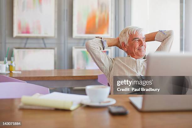 older man using laptop in cafe - senior men cafe stock pictures, royalty-free photos & images