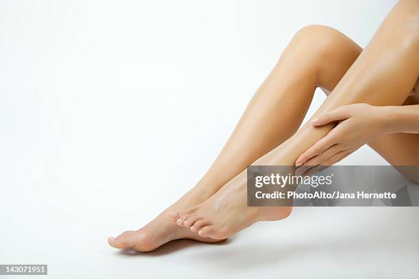 woman moisturizing legs, cropped - 美脚 ストックフォトと画像