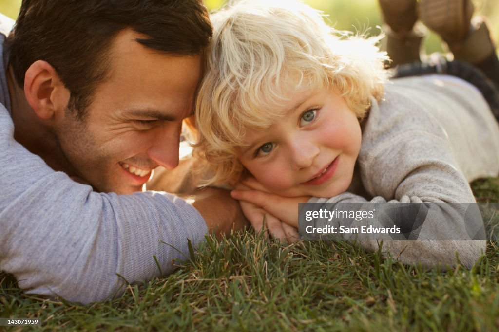 Father and son laying in grass