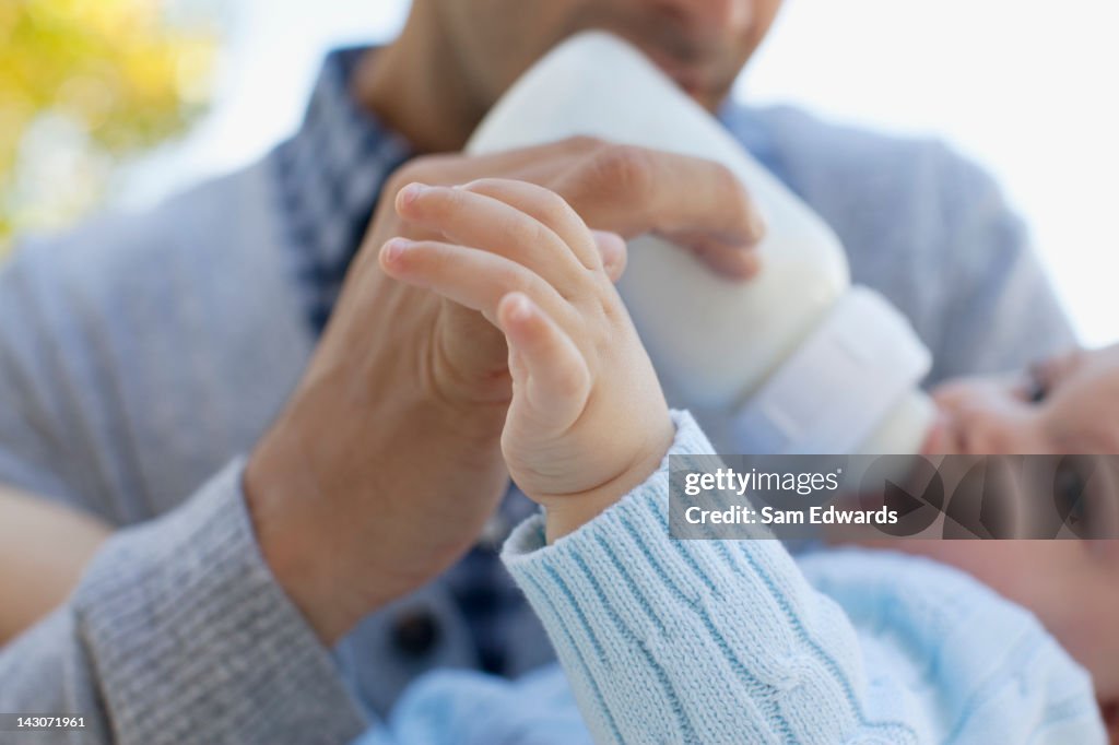 Father feeding baby from bottle