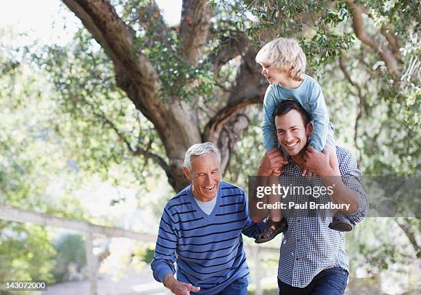 three generations of men walking outdoors - 3 men standing outside stockfoto's en -beelden