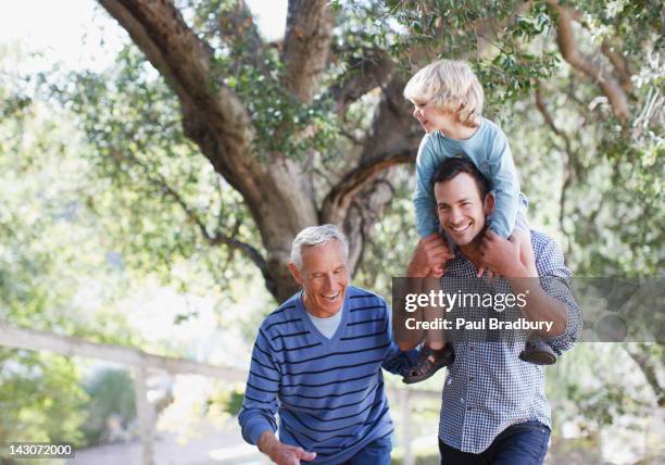 three generations of men walking outdoors - grandpa son stock pictures, royalty-free photos & images