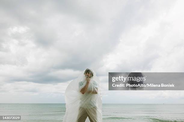 man contemplating in plastic - man wrapped in plastic stock pictures, royalty-free photos & images
