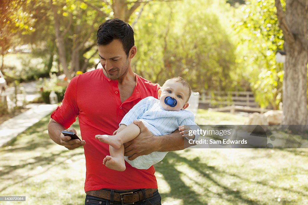 Father with baby using cell phone