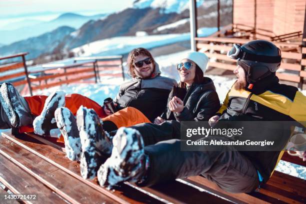 cute female discussing skiing with two male friends - friends skiing stock pictures, royalty-free photos & images