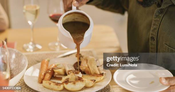 hands pouring sauce, potatoes and food on table for family dinner in home dinning room. gravy, carrots and plate, fine dining or eating, celebration buffet or party, ceremony or luxury gourmet meal. - gravy stock pictures, royalty-free photos & images