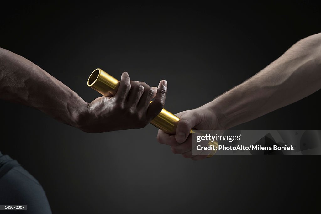 Runners passing baton, cropped
