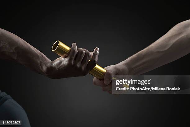 runners passing baton, cropped - relay baton stock pictures, royalty-free photos & images
