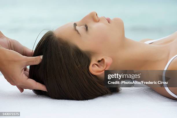 young woman receiving head massage, side view - head massage stock pictures, royalty-free photos & images