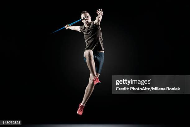 male athlete leaping with javelin - javelin stock pictures, royalty-free photos & images