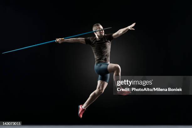 male athlete leaping with javelin - lancer du javelot photos et images de collection