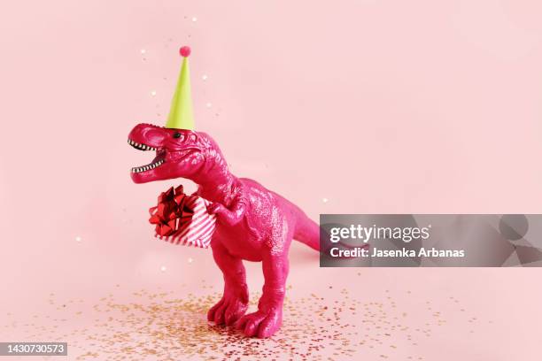 toy dinosaur with birthday gift - cumpleañero fotografías e imágenes de stock