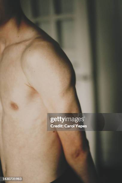 unrecognizable teenager flexing biceps muscles - grote borsten stockfoto's en -beelden