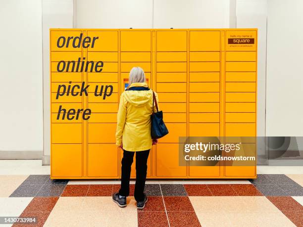 woman collecting goods from amazon locker in the city - click and collect stock pictures, royalty-free photos & images