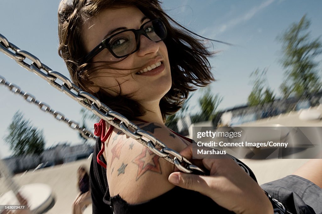 Woman playing on swing in playground