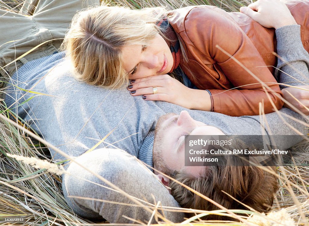 Smiling couple relaxing in grass