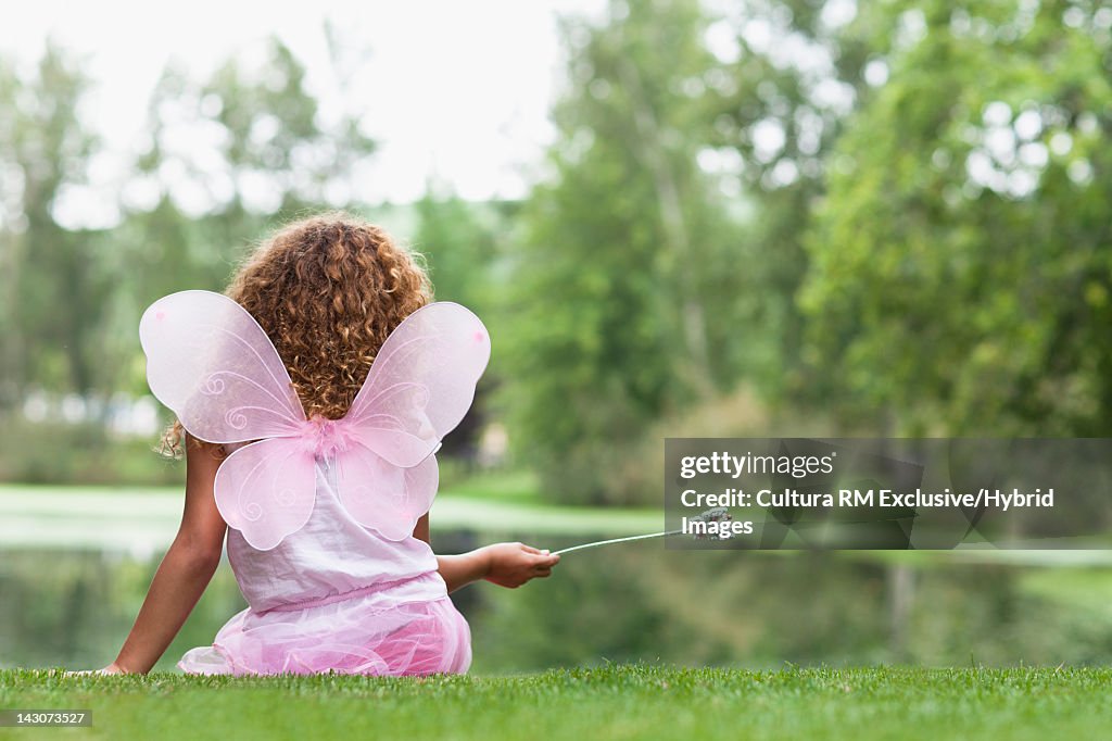 Girl playing with fairy wings and wand