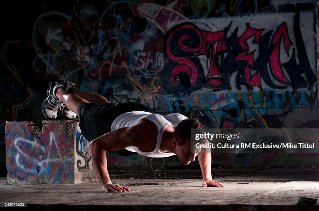 Man doing push-ups in graffitied gym