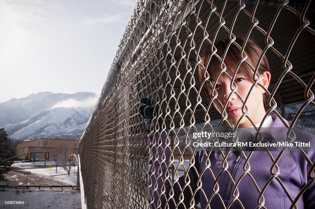 Runner leaning on chain link fence