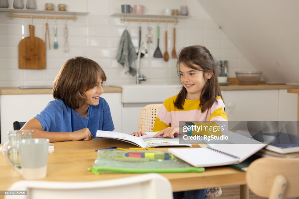 Two Make Homework Two Children Doing Homework Together In Kitchen High-Res Stock Photo ...
