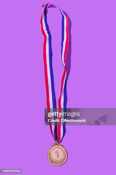 gold medal with the number 1, as the first classified, on a purple background. concept of winner, medals, honor, women's day, winning woman, working woman and sports competition. - médaillé photos et images de collection