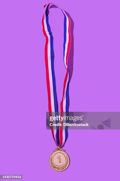 gold medal with the number 1, as the first classified, on a purple background. concept of winner, medals, honor, women's day, winning woman, working woman and sports competition. - gold award stock pictures, royalty-free photos & images