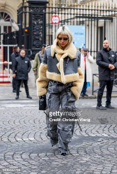 Vanessa Hong wears beige grey shearling jacket, denim jeans with side pockets, black bag outside Sacai during Paris Fashion Week - Womenswear...