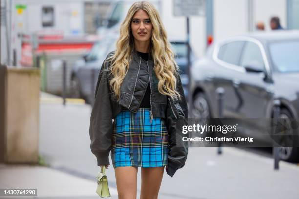 Emili Sindlev wears bomber jacket, blue checkered skirt outside Sacai during Paris Fashion Week - Womenswear Spring/Summer 2023 : Day Eight on...