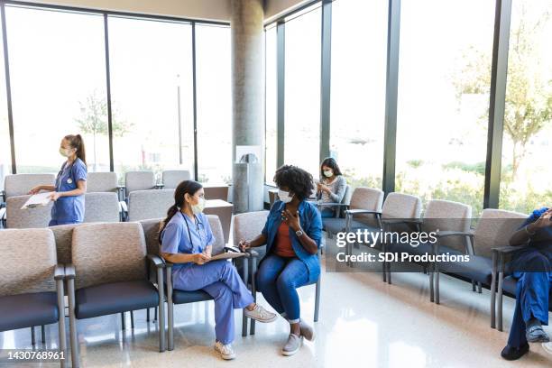 medical staff talking with patients - waiting room clinic stock pictures, royalty-free photos & images