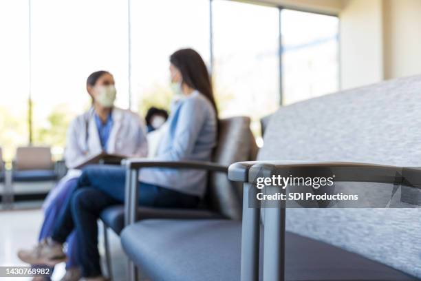 doctor talks with female patient - waiting room clinic stock pictures, royalty-free photos & images