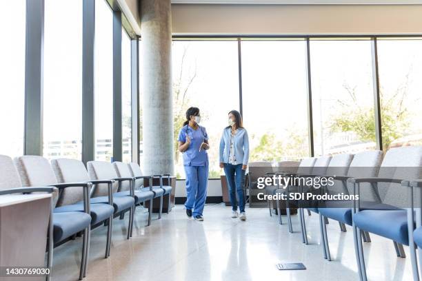 doctor walks with the female patient - coronavirus patient stock pictures, royalty-free photos & images