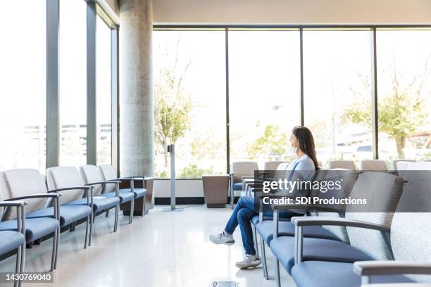 adult female sits in the waiting room - covid 19 triage stock pictures, royalty-free photos & images