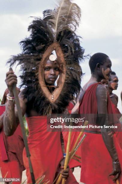 Maasai man with Maasai warrior mask made with ostrich feathers, Tanzania.