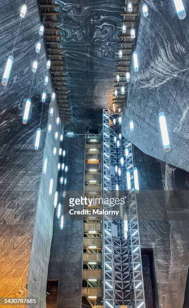 futuristic lights hanging from the ceiling of a mine or cave. symbolizing power, resources and technology in a near future - cure rock hall stock pictures, royalty-free photos & images