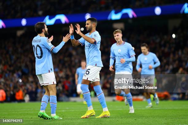 Riyad Mahrez celebrates with Bernardo Silva of Manchester City after scoring their team's fourth goal from the penalty spot during the UEFA Champions...