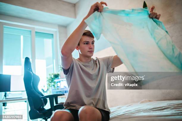 teenager folding his clothes - tidy bedroom stock pictures, royalty-free photos & images