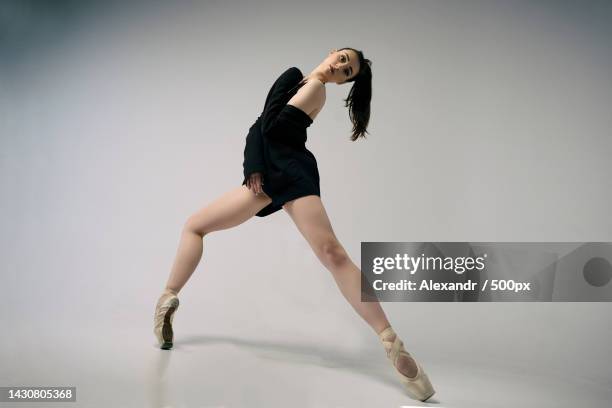 ballerina in a black jacket improvises classical and modern choreography in a photo studio - danseuse photos et images de collection
