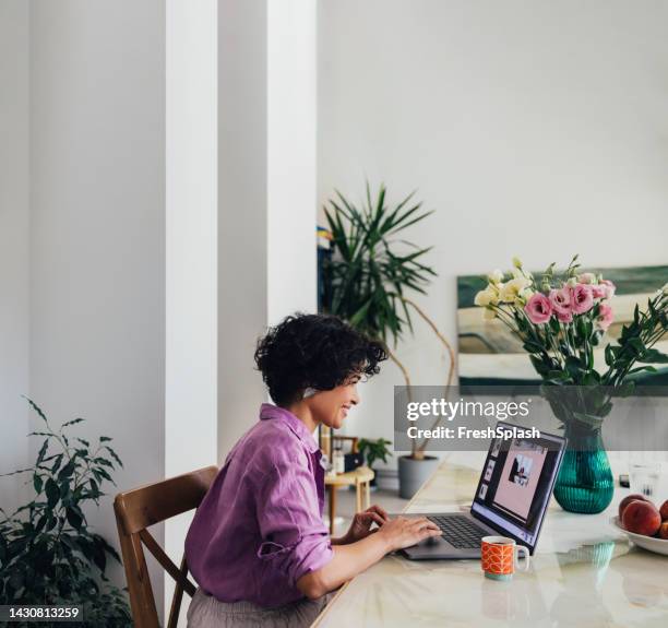 una empresaria feliz trabajando desde casa en su computadora - mujer feliz sola 30 35 fotografías e imágenes de stock