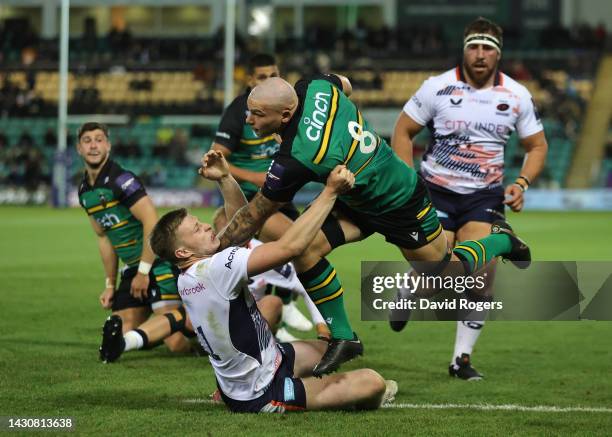 Aaron Hinkley of Northampton Saints is tackled by Francis Moore during the Premiership Rugby Cup match between Northampton Saints and Saracens at...