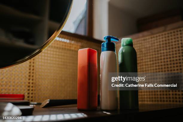 a trio of cosmetic beauty products on a dressing table - hair conditioner stock pictures, royalty-free photos & images