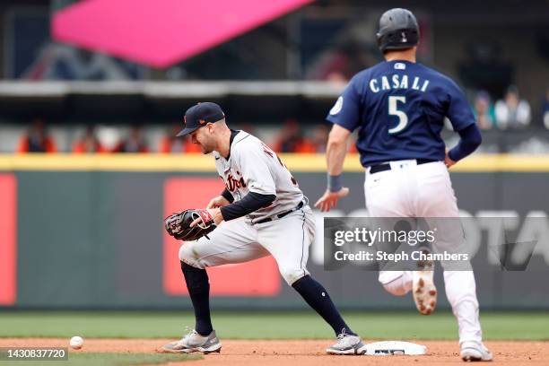 Ryan Kreidler of the Detroit Tigers loses the ball as Curt Casali of the Seattle Mariners safely advances to second base during the ninth inning of...