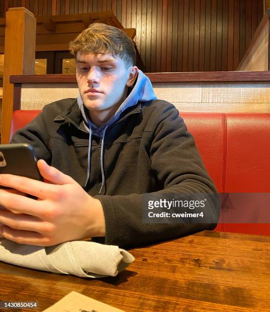 young man looking at phone - kansas city missouri stockfoto's en -beelden
